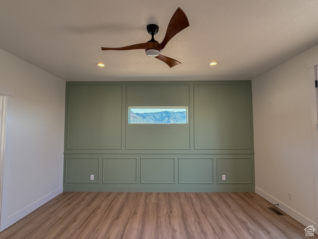 Spare room featuring a decorative wall, light wood-style flooring, baseboards, recessed lighting, and ceiling fan