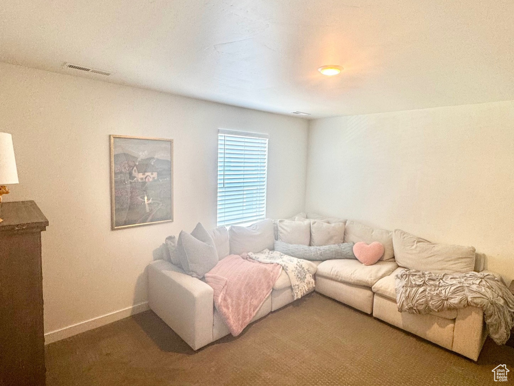 Carpeted living area featuring baseboards