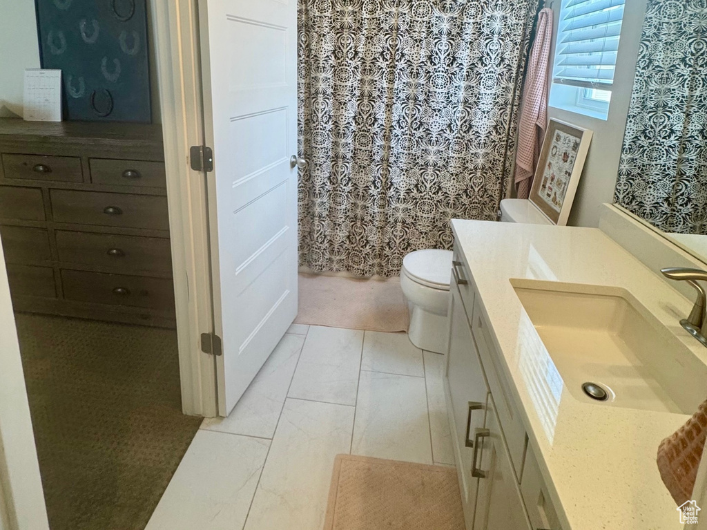 Bathroom featuring vanity, toilet, and a shower with shower curtain
