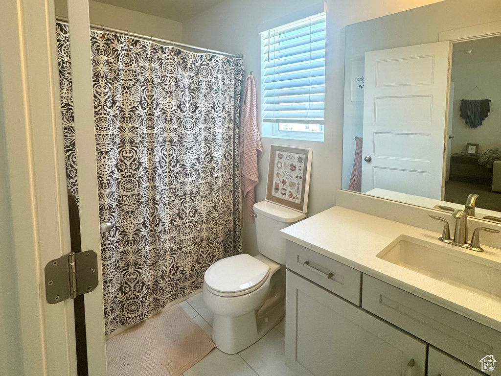 Full bath with vanity, toilet, and marble look tile flooring