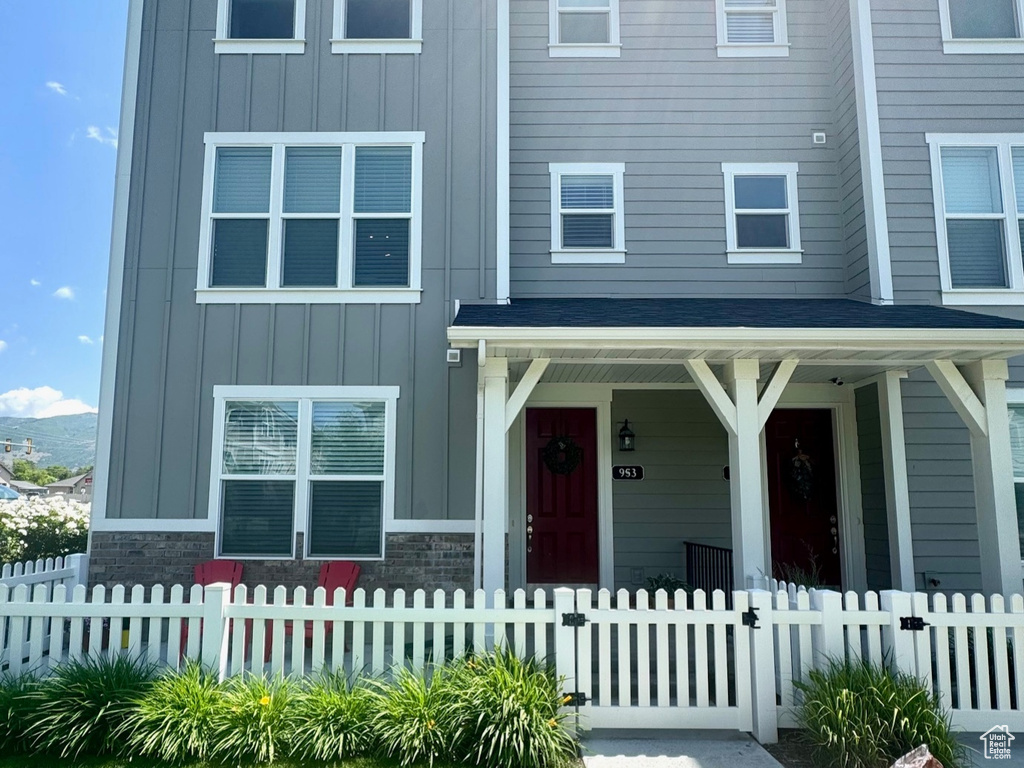 View of front of property featuring board and batten siding, a porch, and a fenced front yard