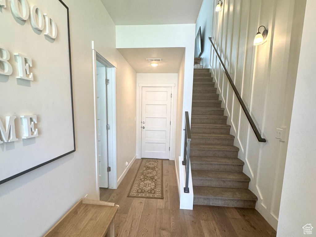 Entryway with wood finished floors, stairs, and baseboards