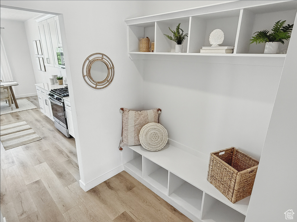 Mudroom with light wood-style flooring and baseboards