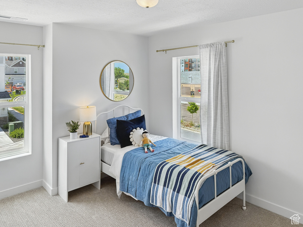Bedroom with light carpet and baseboards