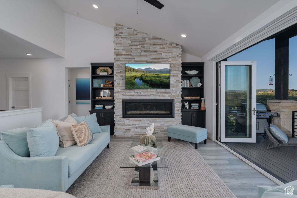 Living room featuring a fireplace, wood finished floors, recessed lighting, high vaulted ceiling, and ceiling fan