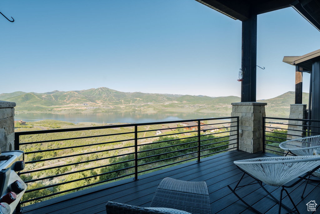 Balcony featuring a water and mountain view