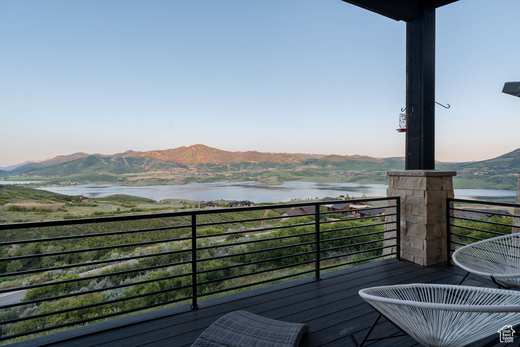 Balcony featuring a water and mountain view
