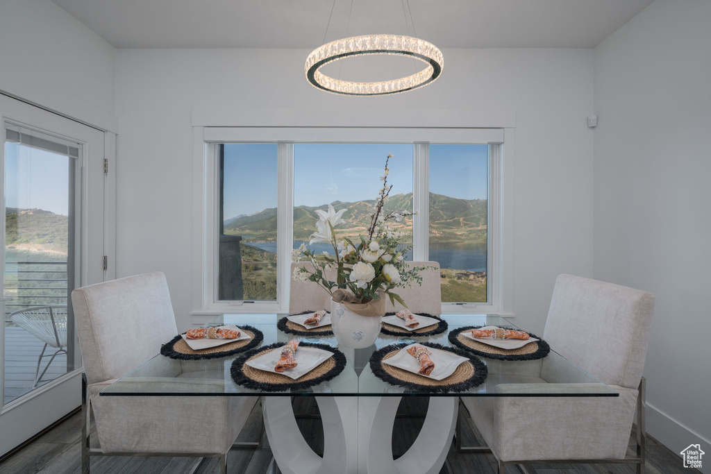 Dining room featuring plenty of natural light, wood finished floors, baseboards, and a mountain view