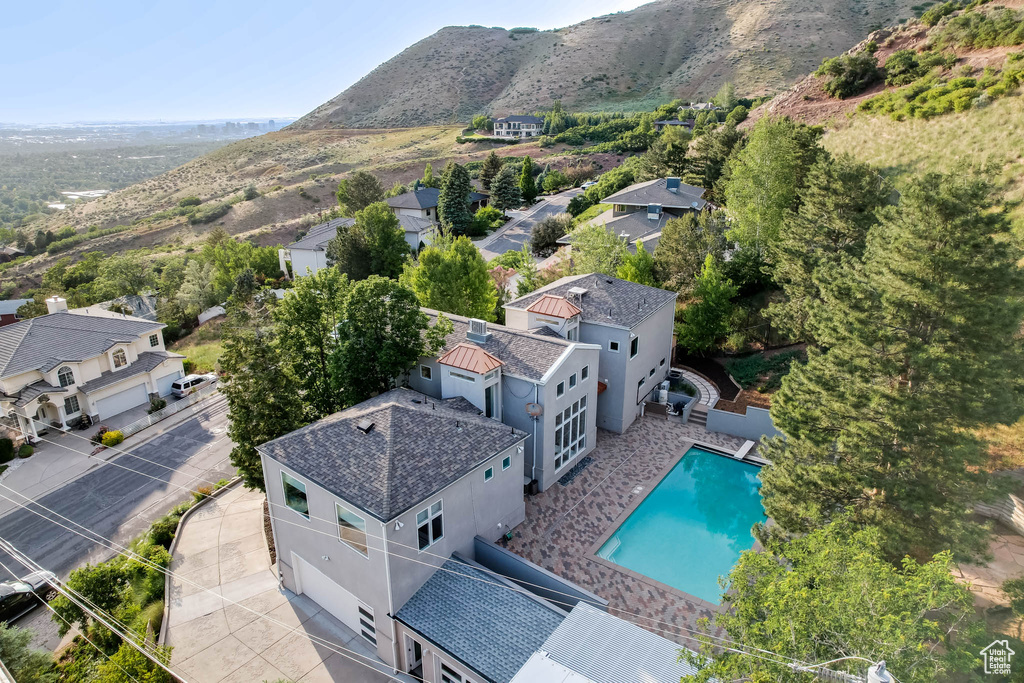 Aerial perspective of suburban area with a mountain backdrop and a pool area