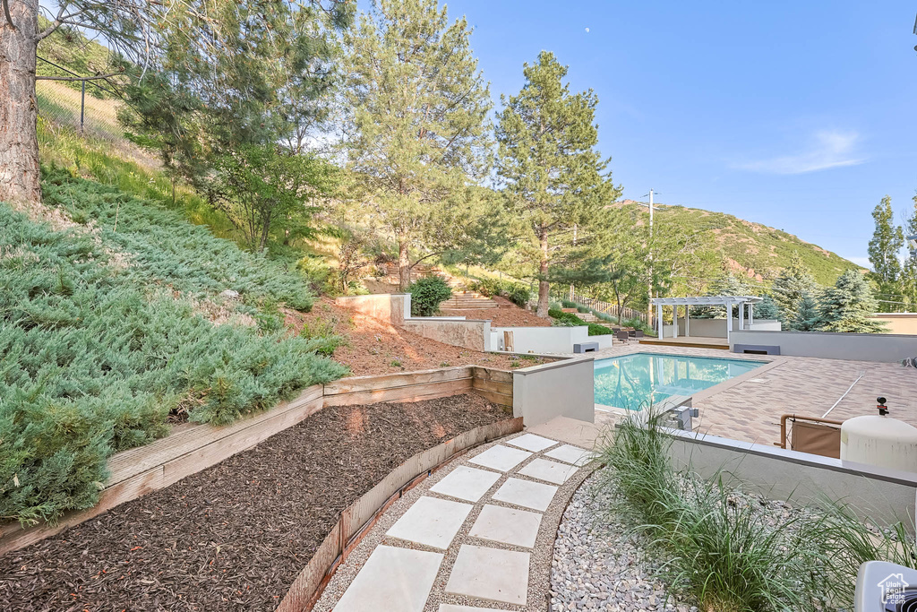 Swimming pool featuring a pergola, a patio area, and a mountain view