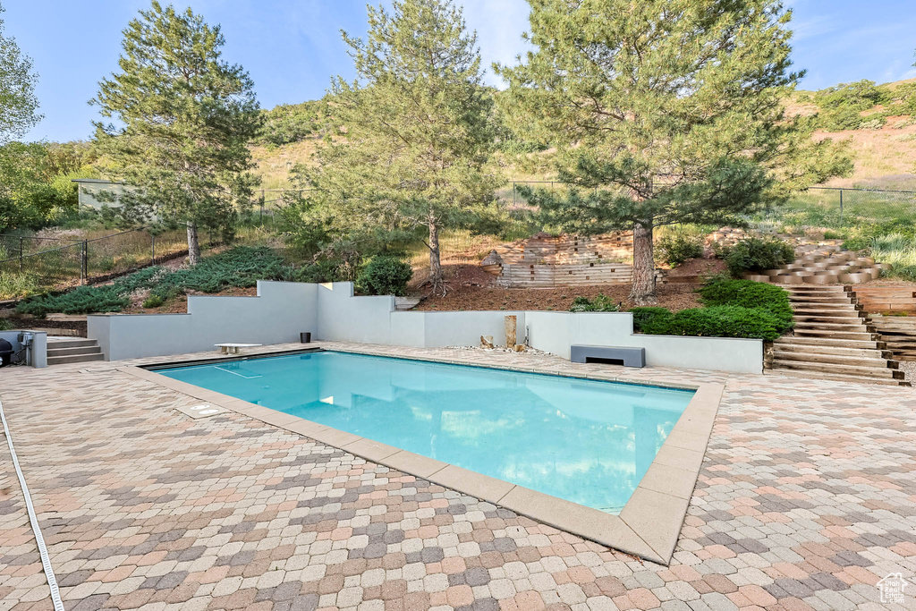 View of swimming pool featuring stairs and a patio area