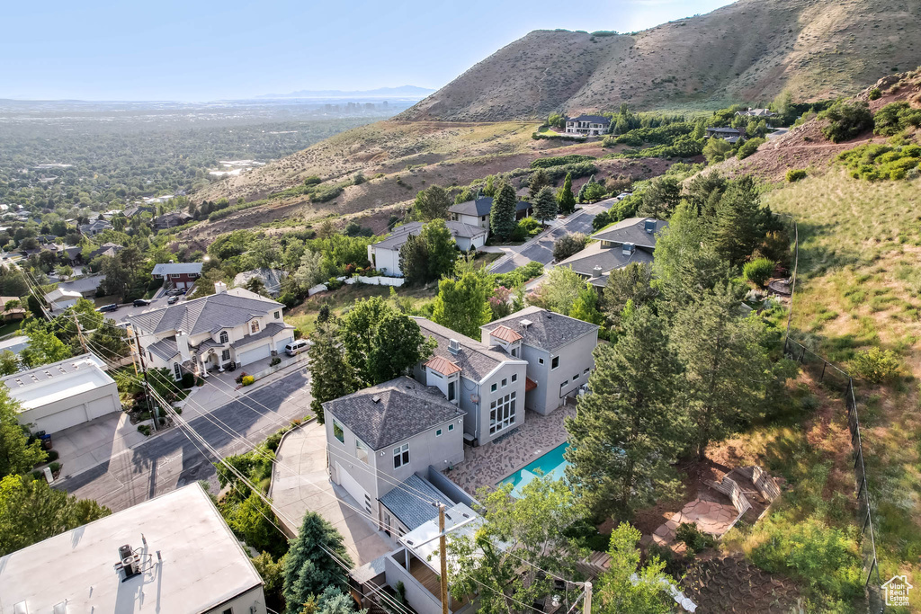 Aerial perspective of suburban area featuring a pool and a mountainous background