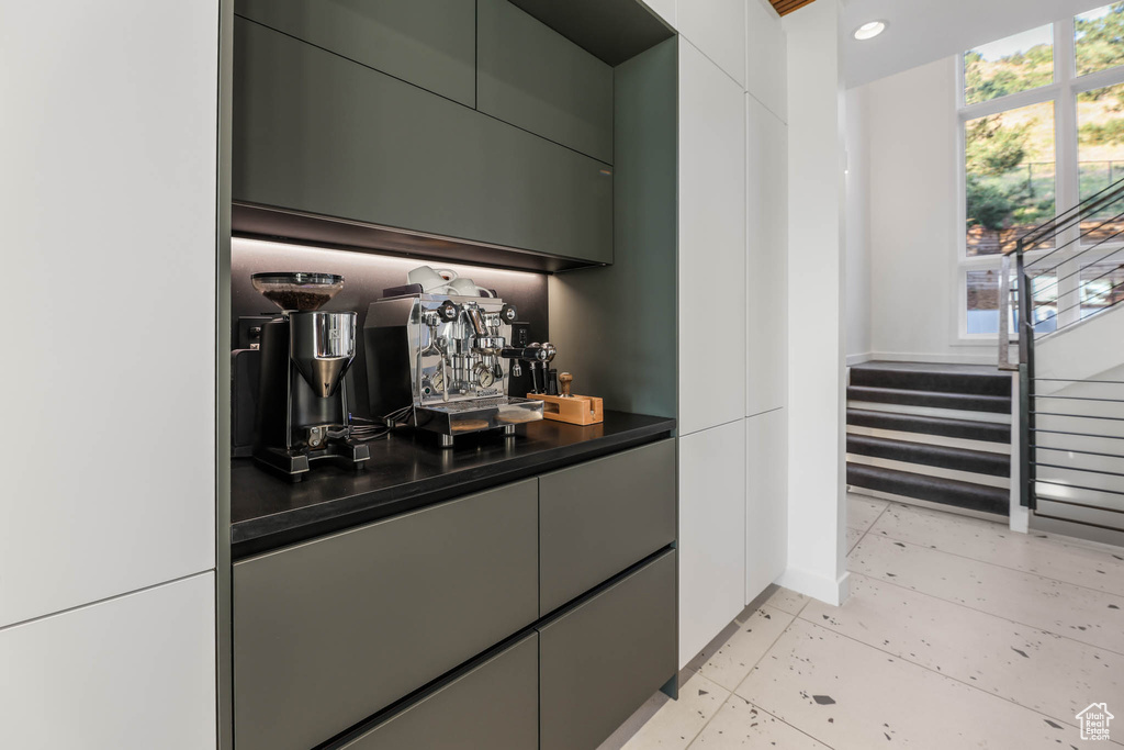 Indoor dry bar featuring stairs, light tile patterned floors, baseboards, and recessed lighting