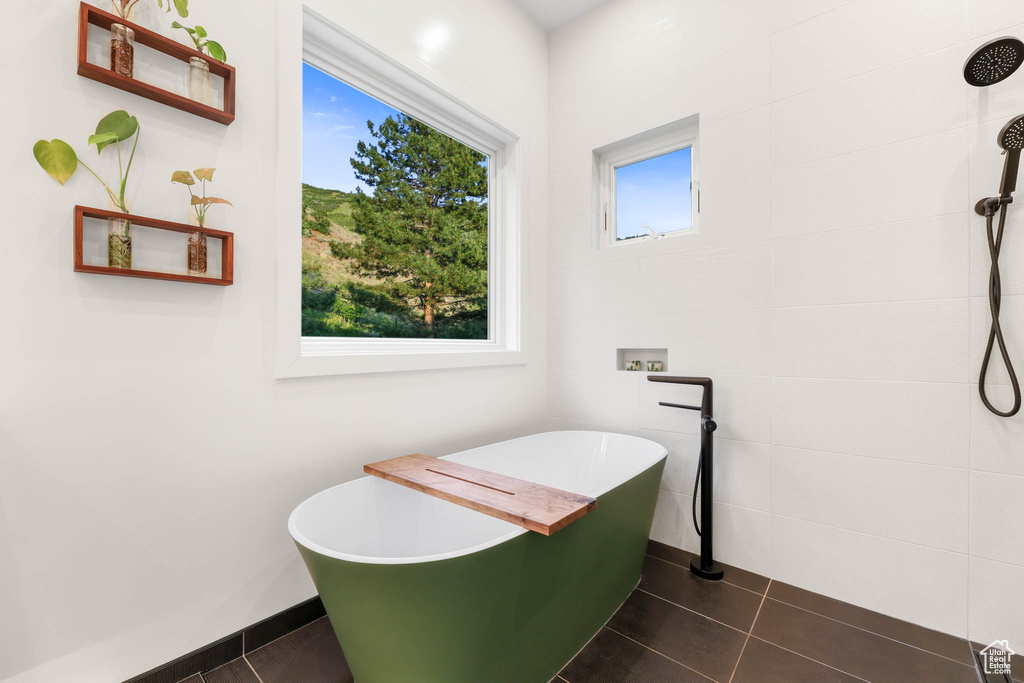 Full bath with a freestanding bath, tile patterned flooring, and baseboards