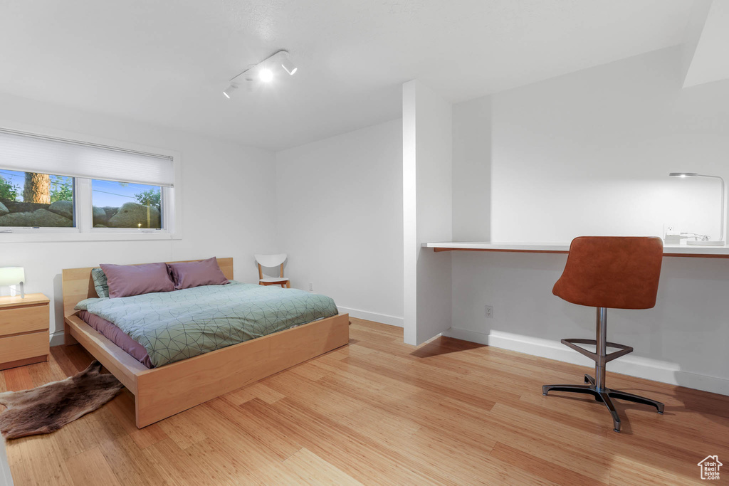 Bedroom featuring wood finished floors and baseboards