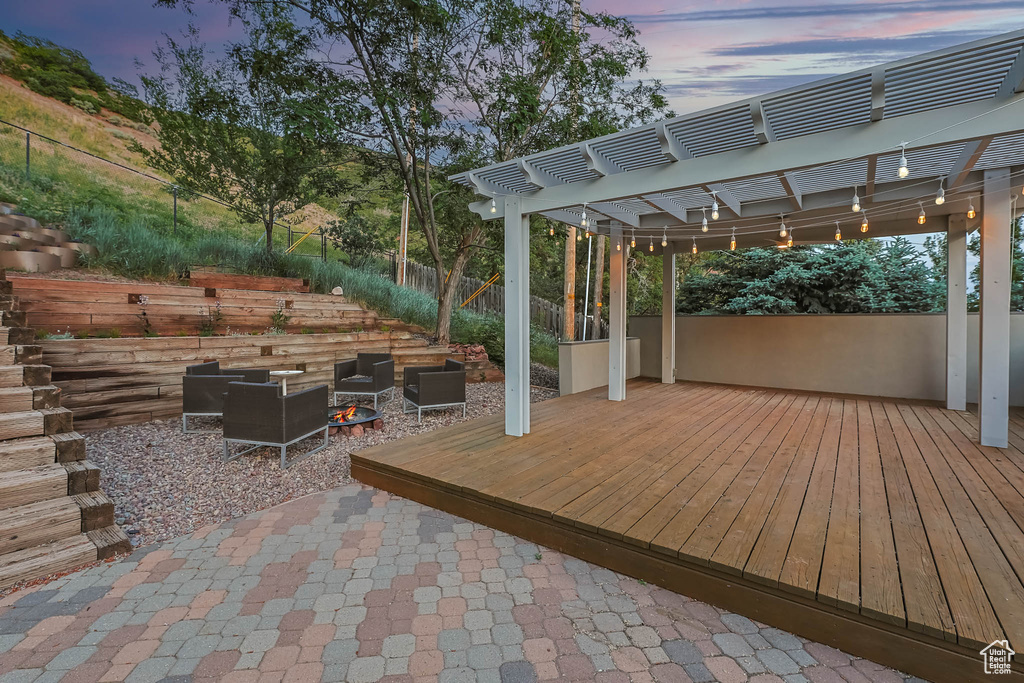 Wooden terrace featuring a pergola and a patio area