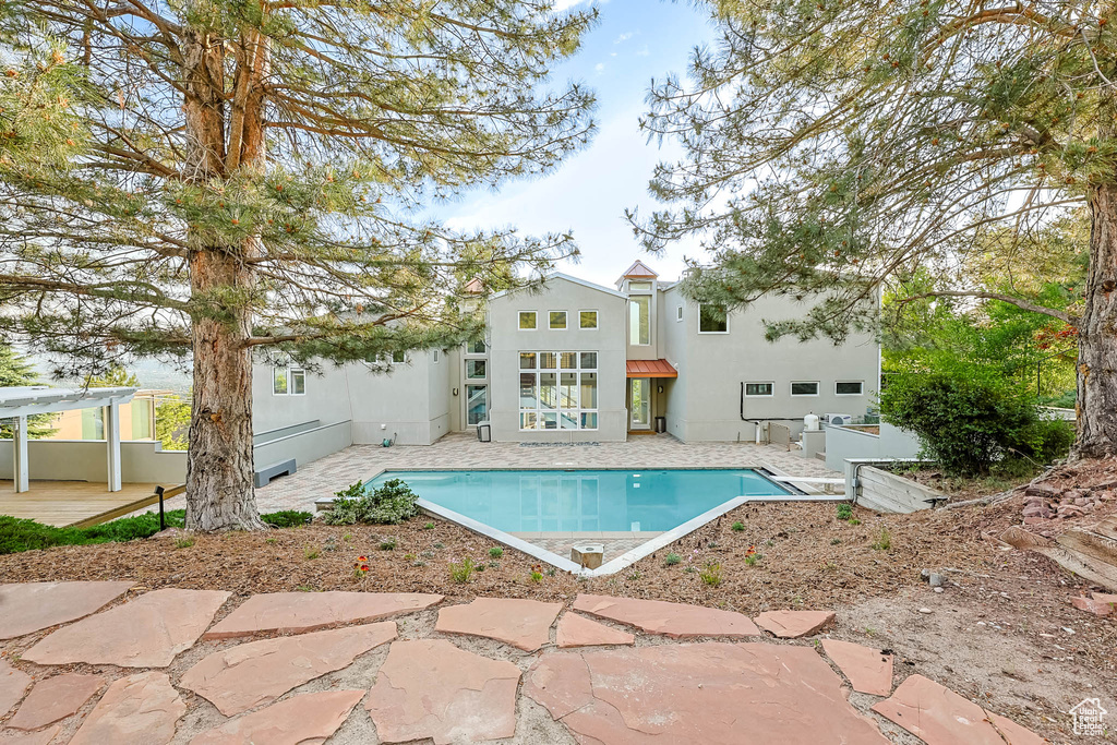Swimming pool with a patio area and a pergola