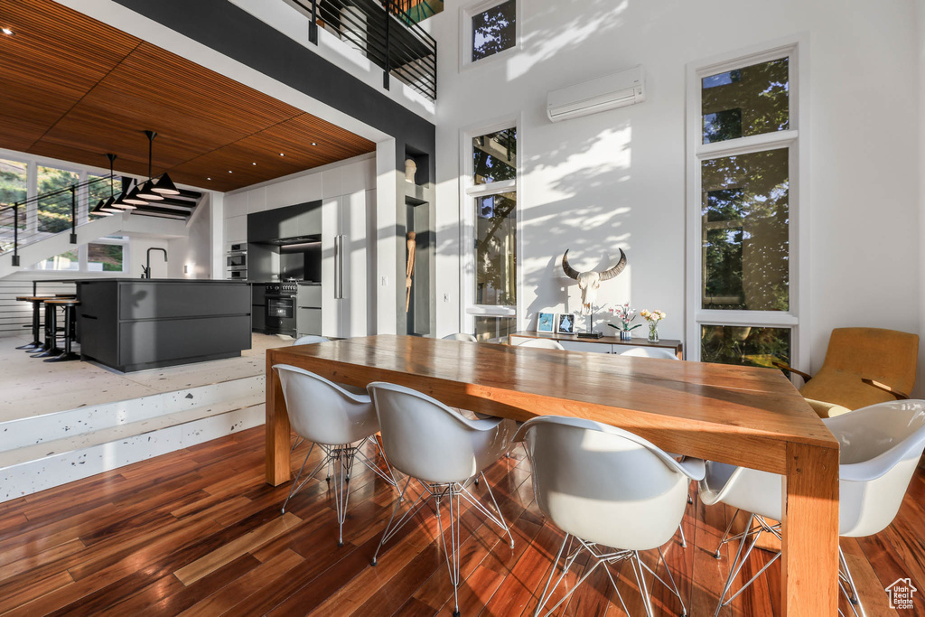 Dining area featuring wooden ceiling, a wall mounted AC, wood finished floors, and recessed lighting