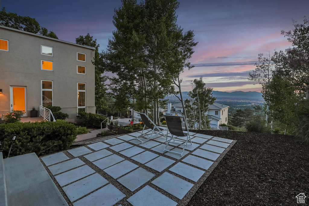 Patio terrace at dusk featuring a patio and a mountain view