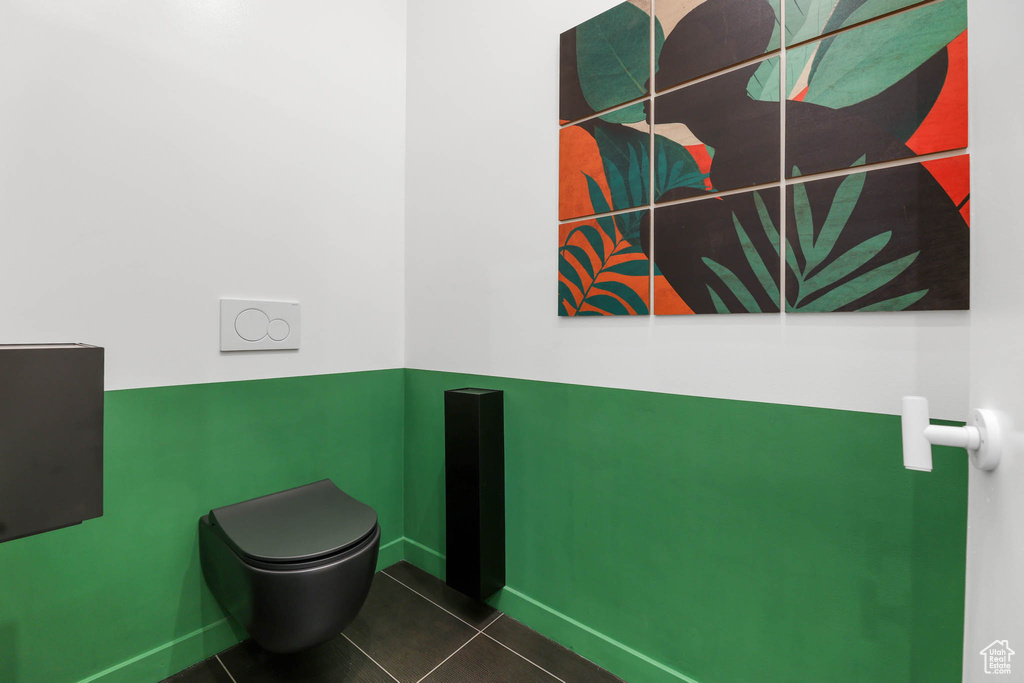 Bathroom featuring tile patterned flooring, baseboards, and toilet