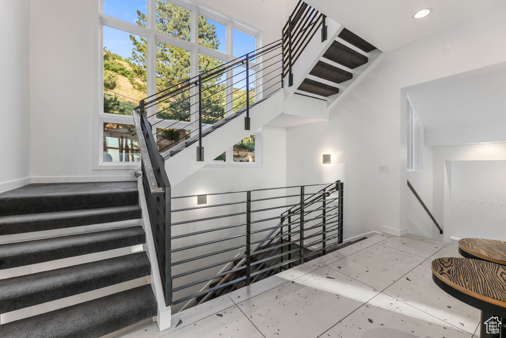 Stairs with recessed lighting and baseboards