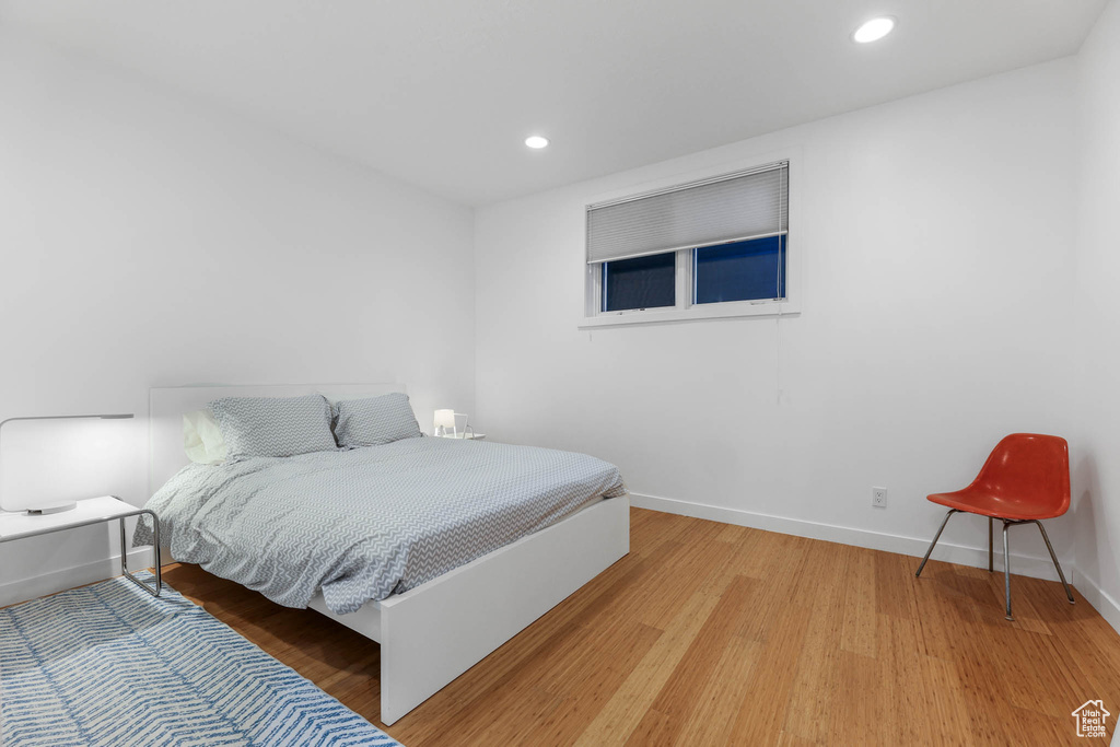 Bedroom with light wood finished floors, baseboards, and recessed lighting