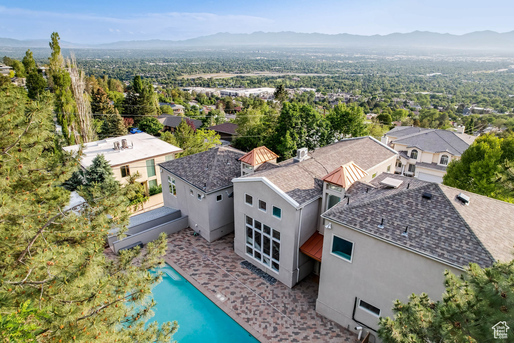 Aerial view of property and surrounding area with a mountain backdrop and a pool area