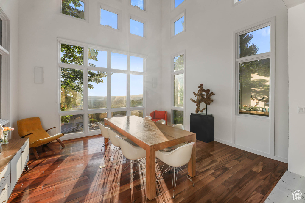 Dining area featuring a high ceiling and dark wood-type flooring