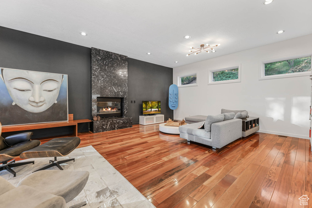 Living area with wood-type flooring, recessed lighting, a premium fireplace, and baseboards