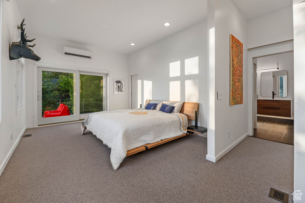 Bedroom with a wall unit AC, carpet floors, baseboards, and recessed lighting