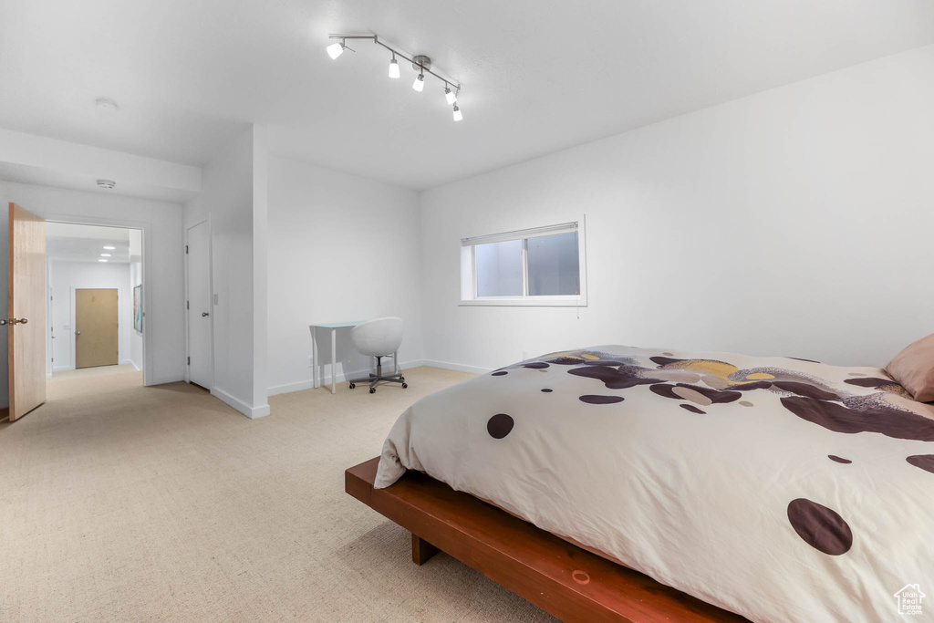 Carpeted bedroom featuring baseboards and track lighting