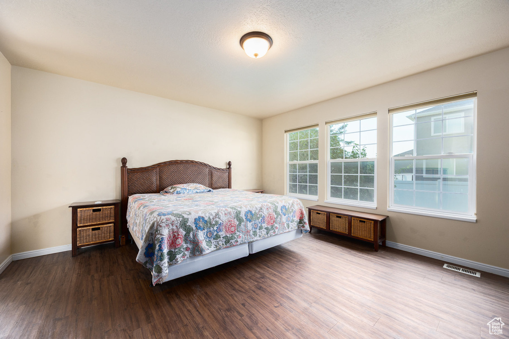 Bedroom with wood finished floors and baseboards