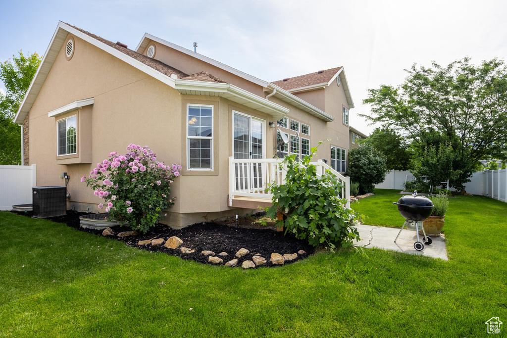 Rear view of house featuring stucco siding and cooling unit