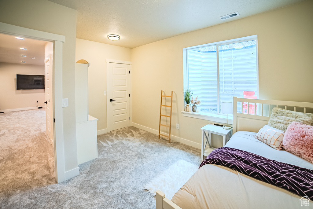 Bedroom with carpet, multiple windows, and baseboards