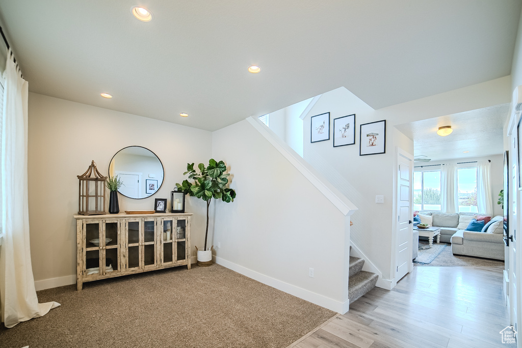 Hallway with stairway, baseboards, wood finished floors, and recessed lighting