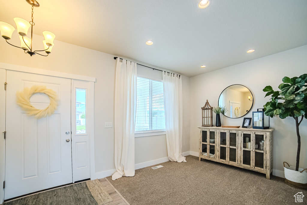 Entrance foyer featuring a chandelier, recessed lighting, and baseboards