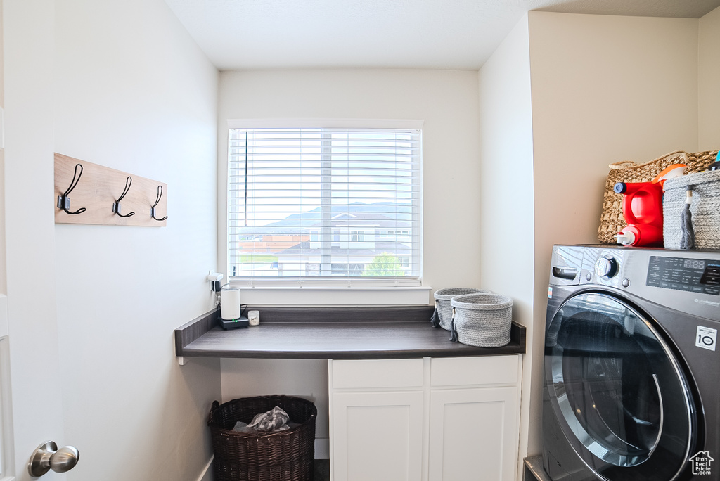 Laundry area featuring washer / dryer and cabinet space