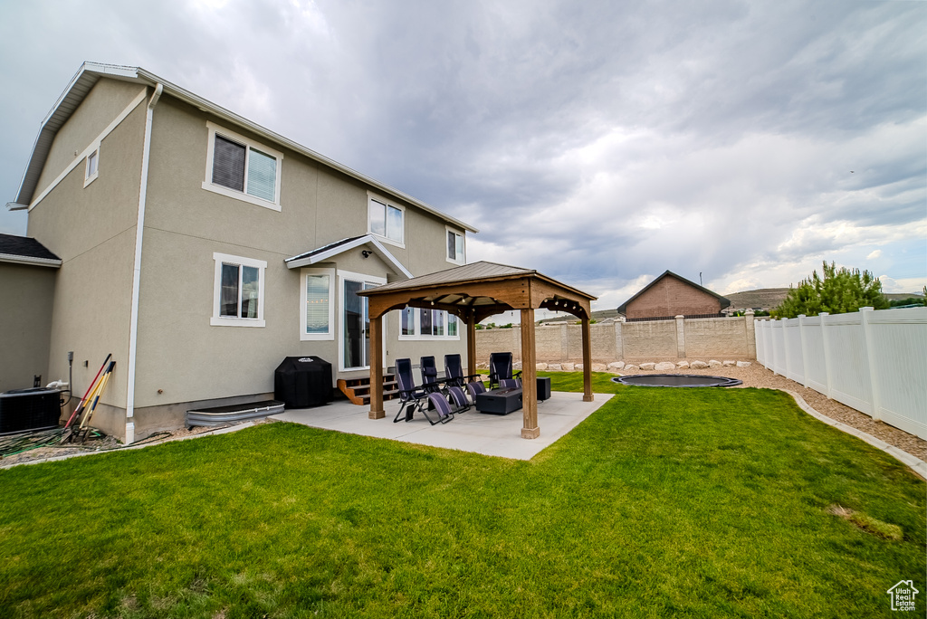 Rear view of property with a gazebo, stucco siding, a patio, and cooling unit
