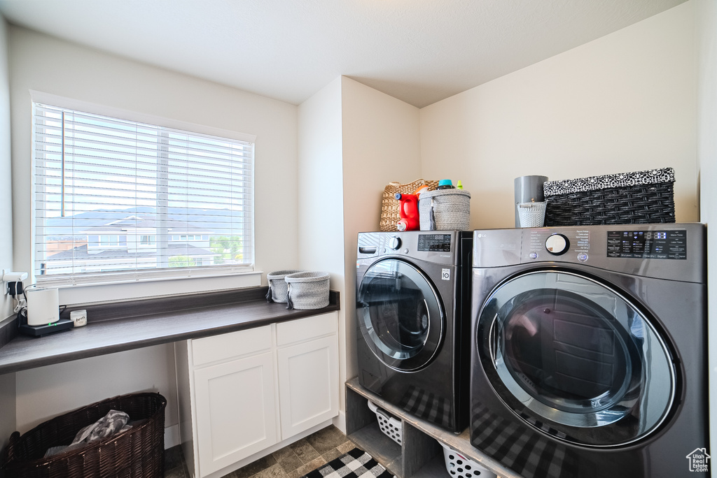 Washroom featuring independent washer and dryer and cabinet space