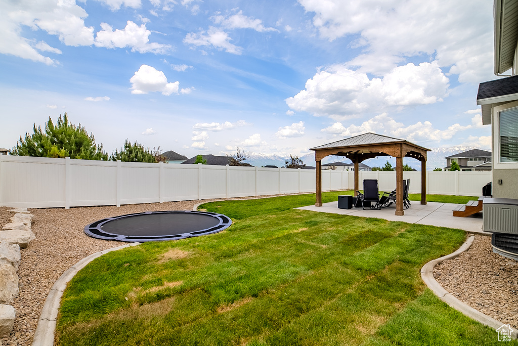 View of yard with a trampoline, a patio, and a gazebo