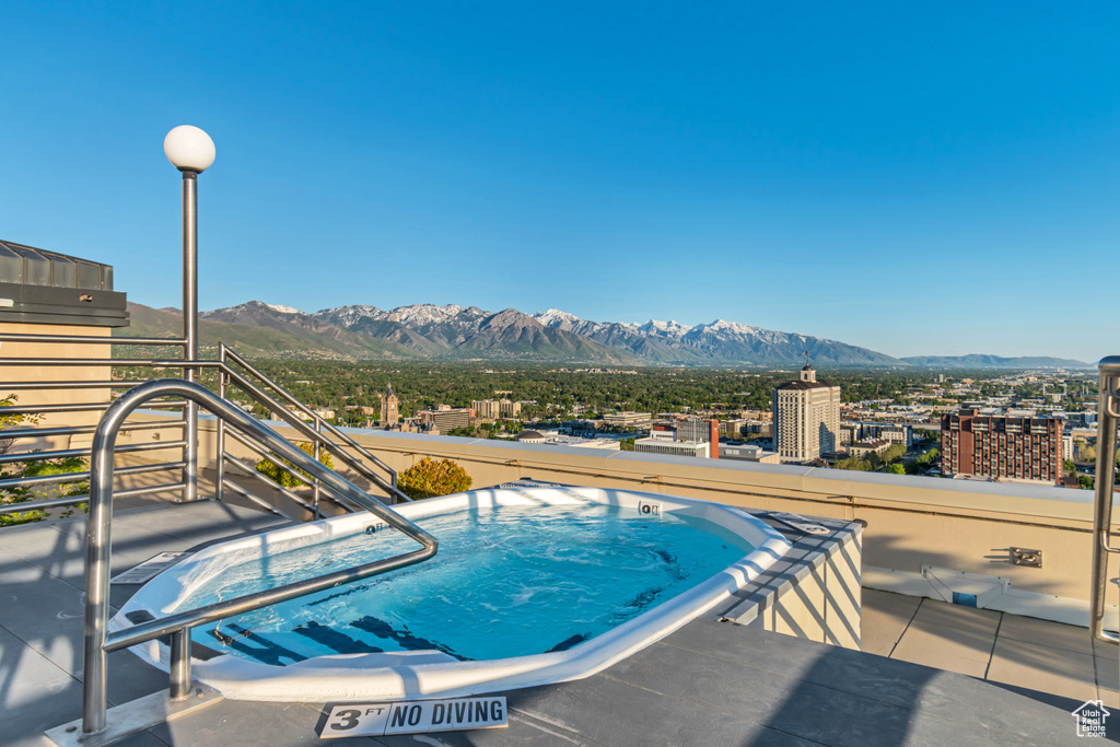 View of pool featuring a mountain view and an outdoor hot tub