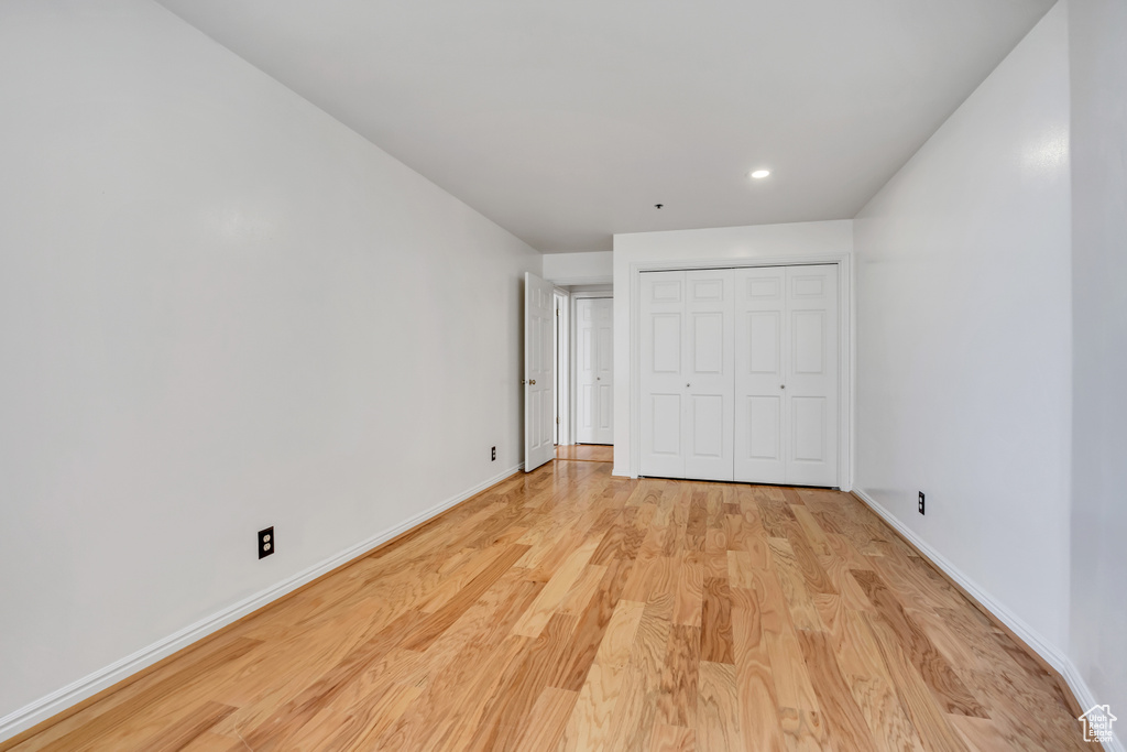 Unfurnished bedroom featuring light wood-style flooring, baseboards, recessed lighting, and a closet