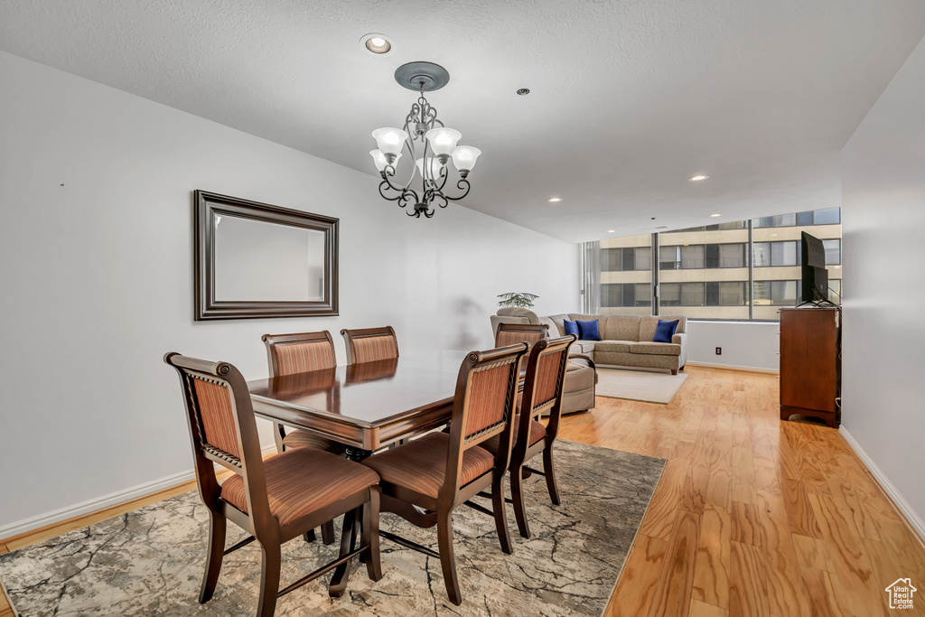 Dining room featuring light wood-type flooring, a chandelier, recessed lighting, and baseboards
