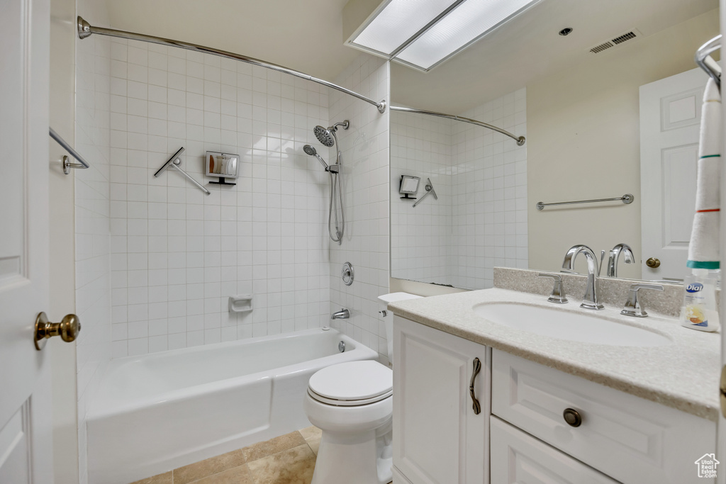 Full bathroom featuring vanity, washtub / shower combination, toilet, and tile patterned flooring
