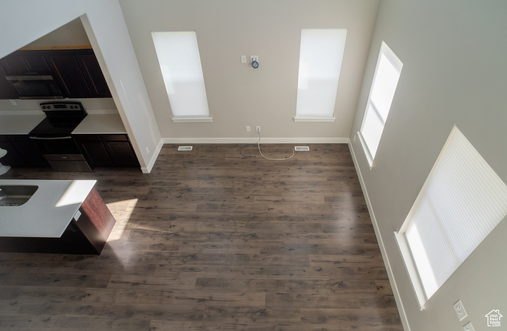 Unfurnished living room with dark wood finished floors and baseboards