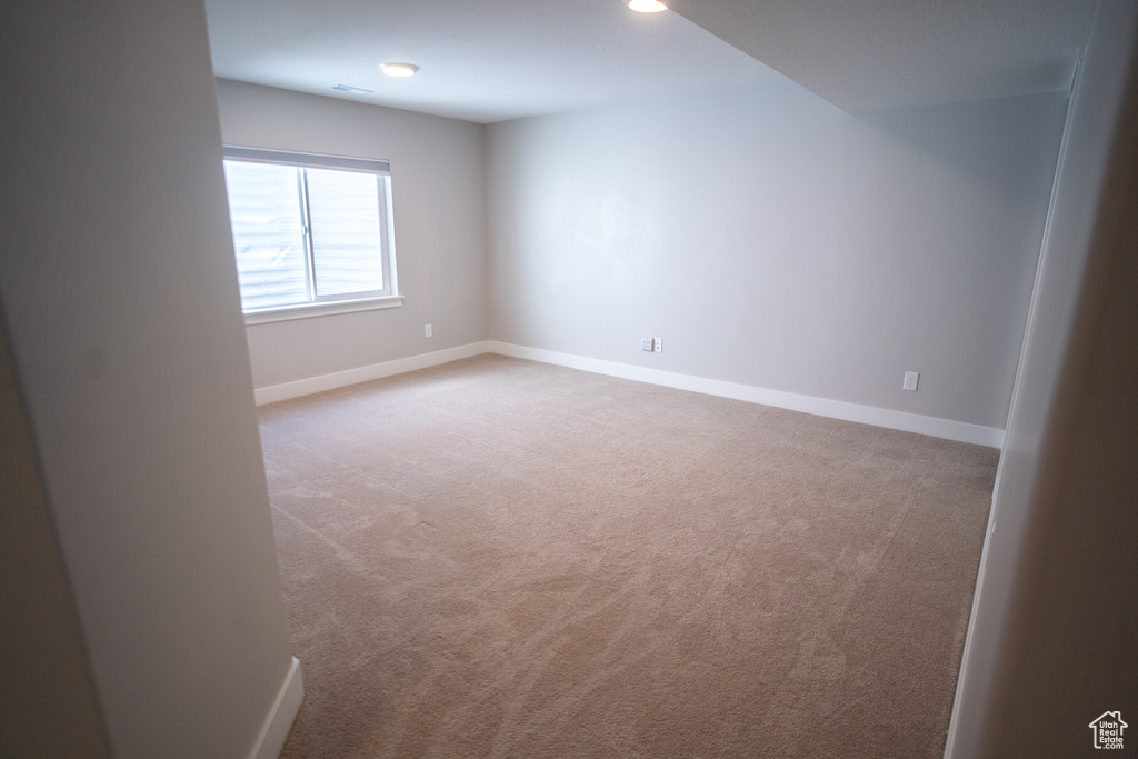 Carpeted spare room featuring baseboards