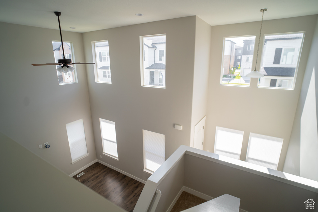 Stairs with a ceiling fan, baseboards, and wood finished floors