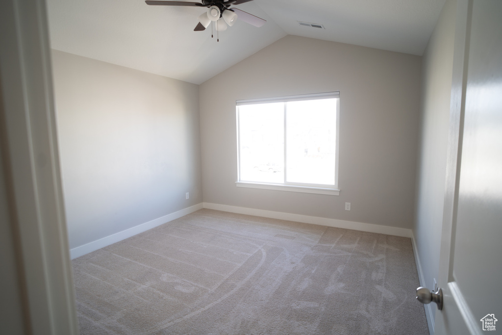 Unfurnished room with a ceiling fan, carpet floors, vaulted ceiling, and baseboards