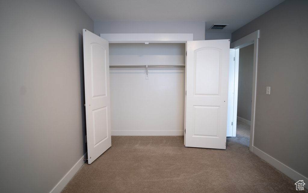 Unfurnished bedroom with carpet, baseboards, and a closet