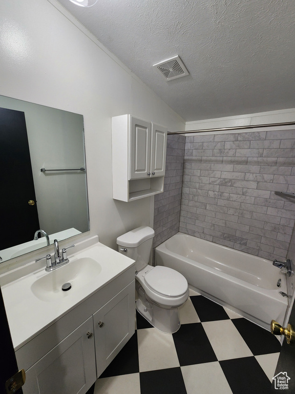Bathroom with tile patterned floors, vanity, toilet, a textured ceiling, and tub / shower combination